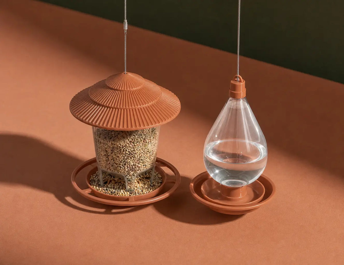 Minimal editorial product portrait, 1.3:1. Place the exact hanging feeder-and-drinker pair alone on